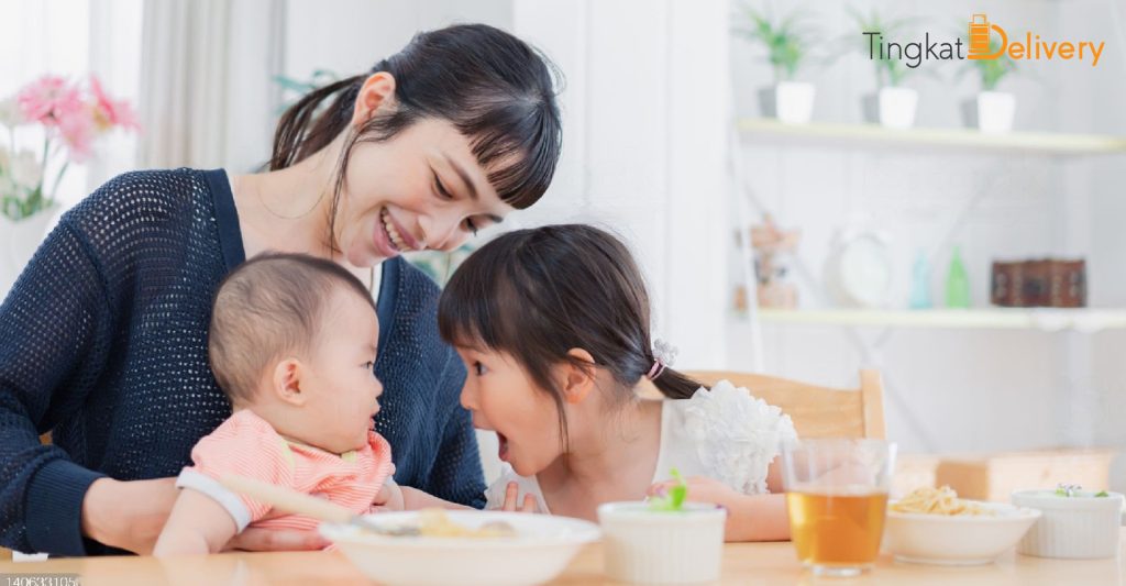 happy mom with her infant and daughter while dining