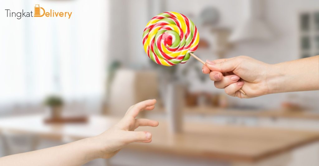 A person's hand reaching for a candy bar - sugar addiction